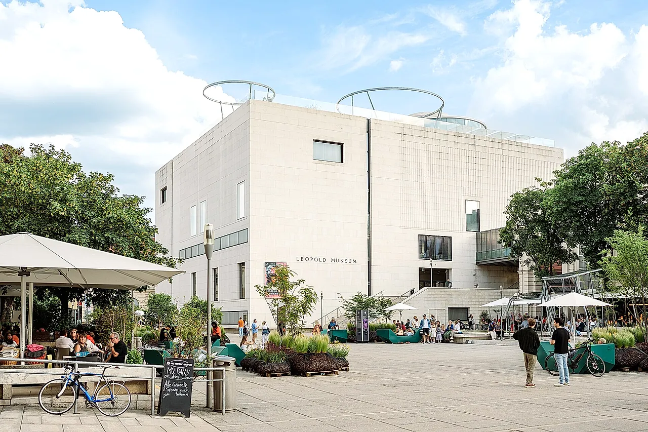 De witte kubus van het Leopold Museum boven de hoofdbinnenplaats van het MuseumsQuartier, met terras en bomen